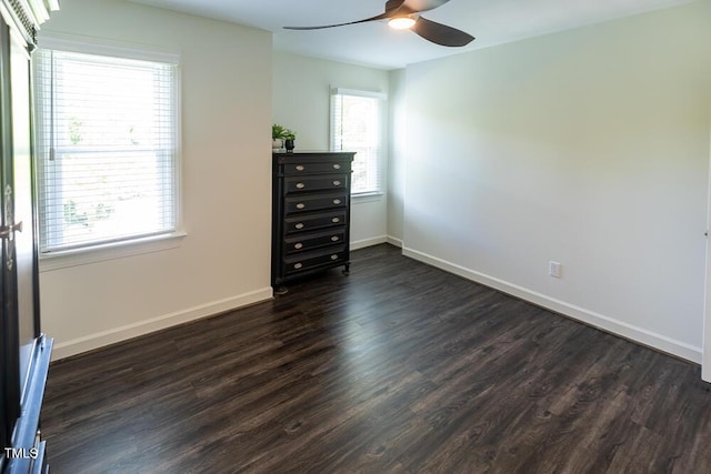 unfurnished bedroom featuring dark wood finished floors, baseboards, and a ceiling fan