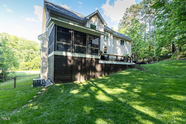 rear view of house with a sunroom, a wooden deck, and central AC