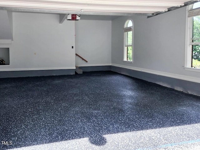 garage featuring a garage door opener and baseboards