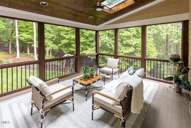 sunroom with a skylight, a ceiling fan, lofted ceiling, and an outdoor living space