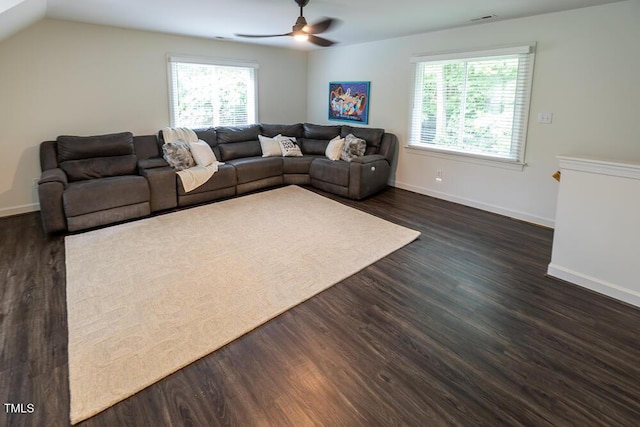 living area featuring a ceiling fan, healthy amount of natural light, dark wood-type flooring, and baseboards