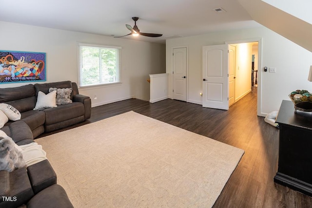 living room with dark wood-style floors, a ceiling fan, and baseboards