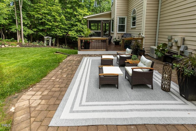 view of patio / terrace featuring a sunroom, a wooden deck, and an outdoor living space