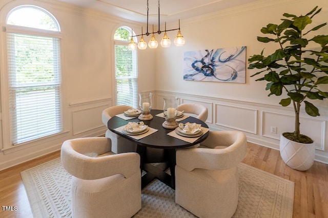 5025 Martin Farm Rd, Raleigh, NC 27613 - dining room with light wood-type flooring, healthy amount of natural light, wainscoting, a decorative wall, and crown molding