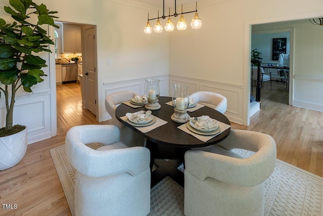 5025 Martin Farm Rd, Raleigh, NC 27613 - dining space with crown molding, light wood-style flooring, a decorative wall, and wainscoting