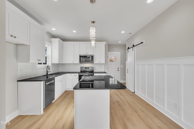 617 Ray St, Selma, NC 27576 - kitchen with white cabinets, a center island, a sink, stainless steel appliances, and backsplash
