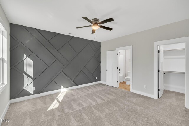 617 Ray St, Selma, NC 27576 - unfurnished bedroom featuring baseboards, a spacious closet, a ceiling fan, a decorative wall, and carpet