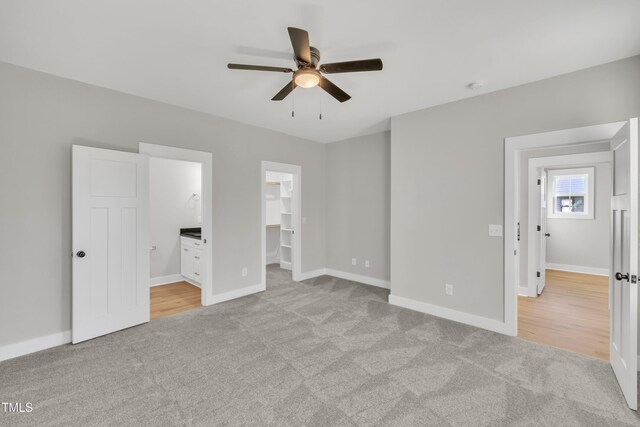 617 Ray St, Selma, NC 27576 - unfurnished bedroom with ensuite bathroom, baseboards, a walk in closet, and carpet