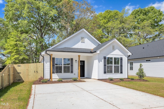 617 Ray St, Selma, NC 27576 - modern farmhouse style home with roof with shingles, a gate, board and batten siding, a front lawn, and fence