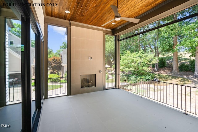 unfurnished sunroom with a ceiling fan and a wealth of natural light
