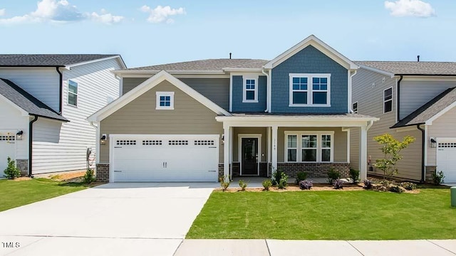 craftsman-style house featuring concrete driveway, a front yard, covered porch, brick siding, and a garage