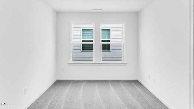 empty room featuring carpet and baseboards