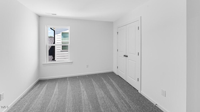 carpeted empty room with baseboards