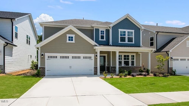 view of front of house featuring a porch, driveway, a front yard, and brick siding