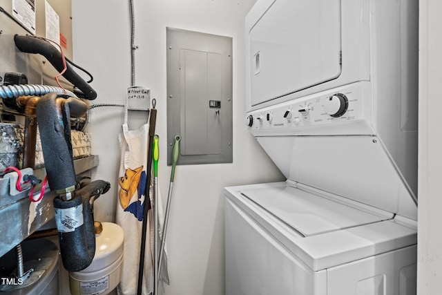 laundry area featuring stacked washer / drying machine and electric panel