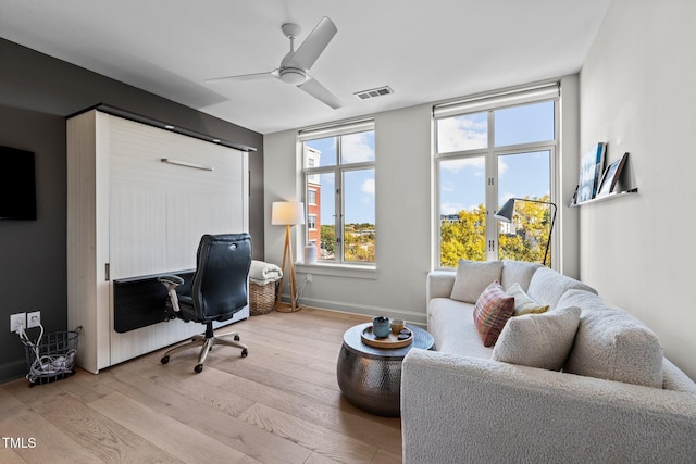 office with light wood-style flooring, ceiling fan, and baseboards