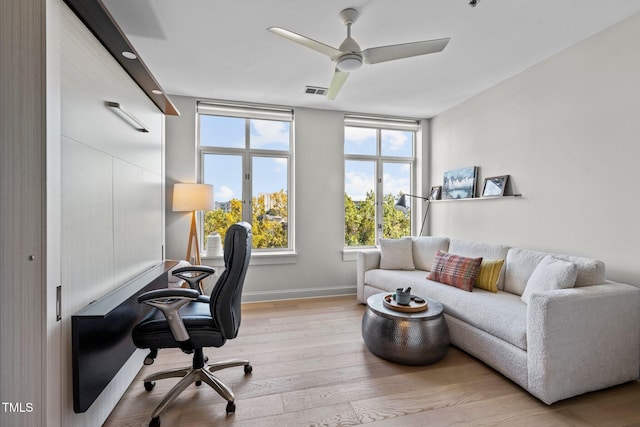 home office with ceiling fan, light wood-style flooring, and baseboards