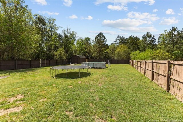 4016 Baywood Point Dr, Fayetteville, NC 28312 - view of yard with a trampoline, a fenced backyard, and a fenced in pool