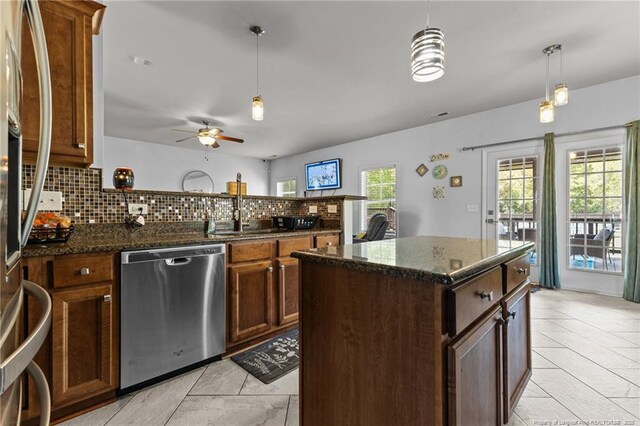 4016 Baywood Point Dr, Fayetteville, NC 28312 - kitchen with a peninsula, appliances with stainless steel finishes, a sink, decorative light fixtures, and decorative backsplash