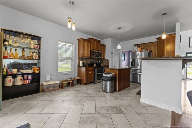 4016 Baywood Point Dr, Fayetteville, NC 28312 - kitchen with a center island, decorative light fixtures, appliances with stainless steel finishes, brown cabinets, and backsplash