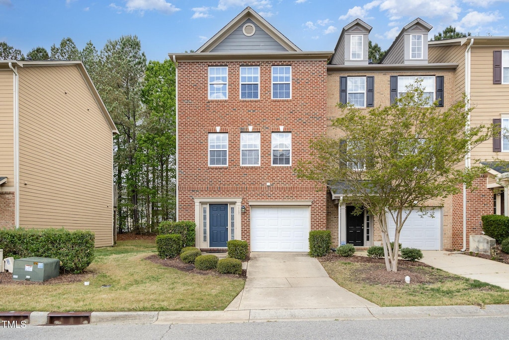 view of property with brick siding, a front yard, and driveway