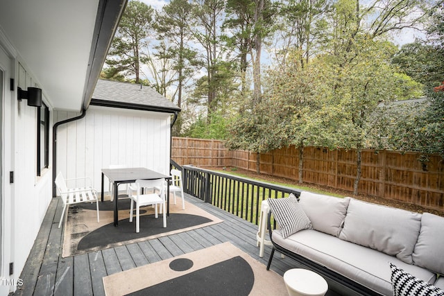 deck with an outdoor living space, a fenced backyard, and outdoor dining area