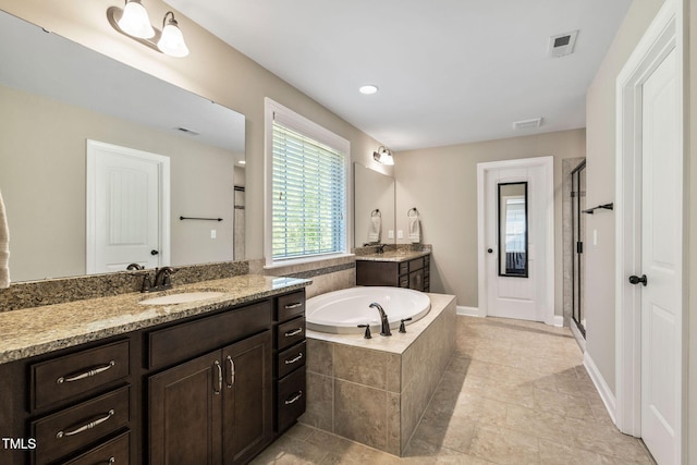 full bath with two vanities, a shower stall, a bath, a sink, and visible vents