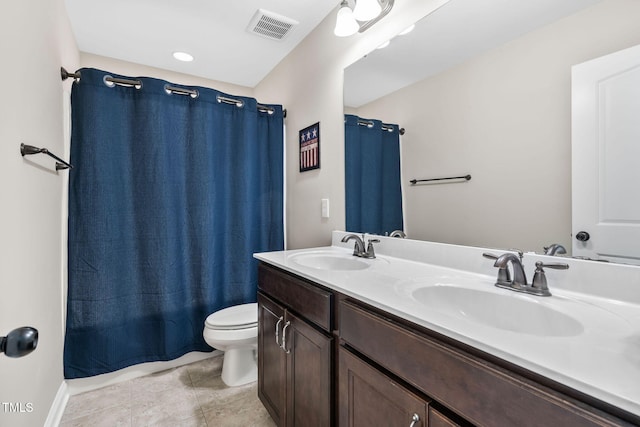 bathroom featuring double vanity, visible vents, toilet, and a sink