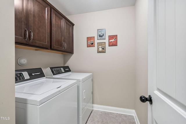 laundry area with baseboards, washer and dryer, cabinet space, and light tile patterned flooring
