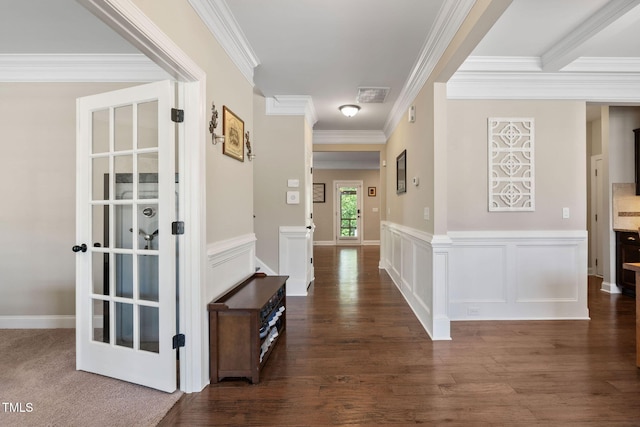 hall featuring dark wood-style flooring, visible vents, and ornamental molding