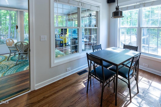 dining area with baseboards, visible vents, a wealth of natural light, and dark wood-type flooring