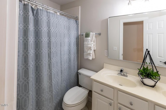 bathroom with toilet, a shower with shower curtain, and vanity