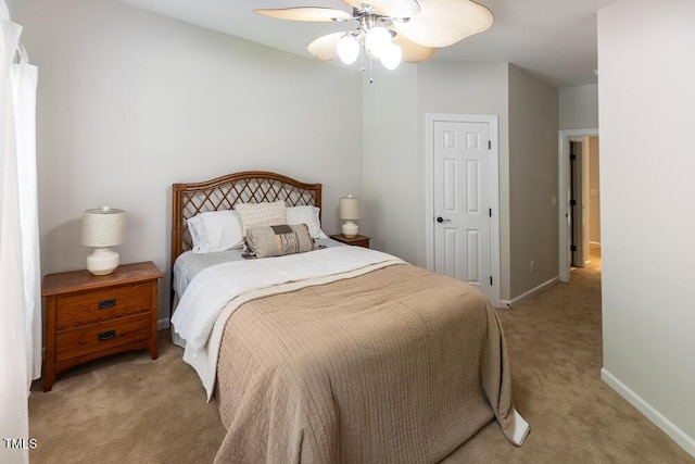 bedroom featuring baseboards, light carpet, and a ceiling fan