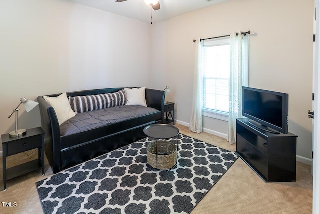 carpeted living area featuring baseboards and ceiling fan