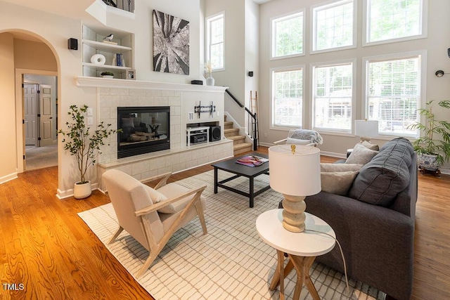 5129 Bartons Enclave Ln, Raleigh, NC 27613 - living room featuring arched walkways, light wood finished floors, baseboards, and a high ceiling