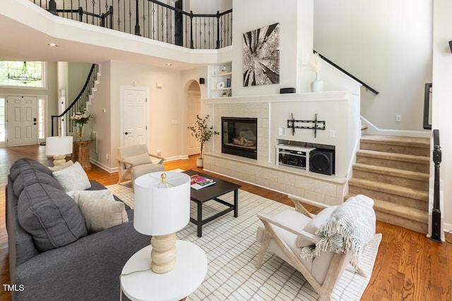 5129 Bartons Enclave Ln, Raleigh, NC 27613 - living room with stairway, a towering ceiling, wood finished floors, arched walkways, and baseboards