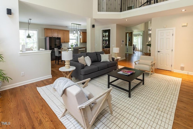 5129 Bartons Enclave Ln, Raleigh, NC 27613 - living area featuring plenty of natural light, baseboards, light wood-style flooring, and a high ceiling