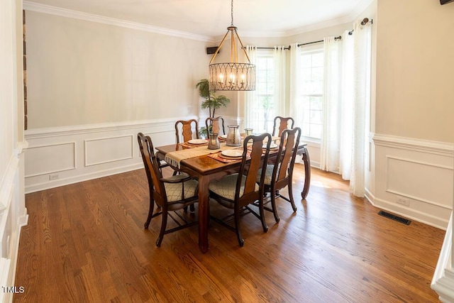 5129 Bartons Enclave Ln, Raleigh, NC 27613 - dining room featuring a chandelier, crown molding, wood finished floors, a wainscoted wall, and a decorative wall