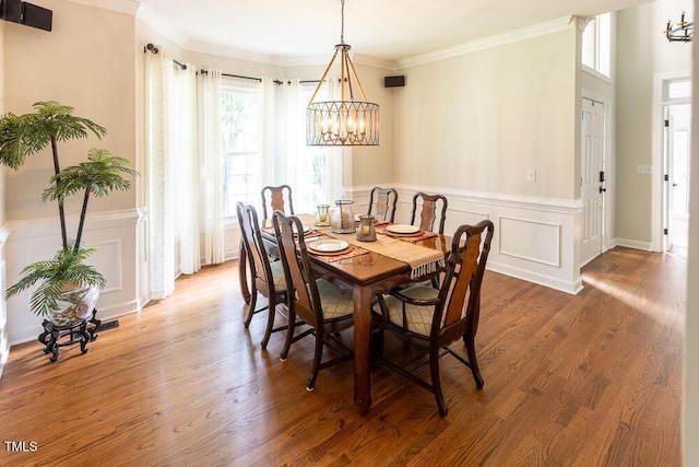 5129 Bartons Enclave Ln, Raleigh, NC 27613 - dining space featuring a chandelier, a wainscoted wall, ornamental molding, a decorative wall, and wood finished floors