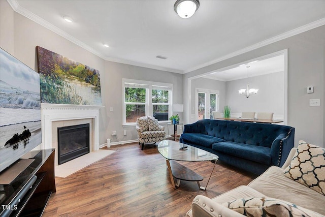 108 Princess Pl, Morrisville, NC 27560 - living room with ornamental molding, an inviting chandelier, wood finished floors, and a fireplace with flush hearth