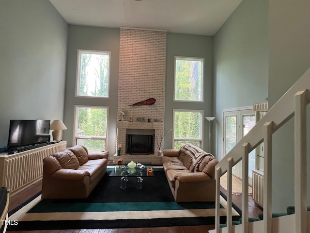 106 Orchard Rd, Henderson, NC 27536 - living room with a high ceiling, a brick fireplace, wood finished floors, and french doors