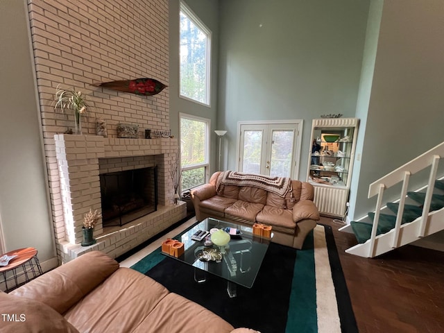106 Orchard Rd, Henderson, NC 27536 - living area featuring a high ceiling, healthy amount of natural light, a fireplace, wood finished floors, and radiator