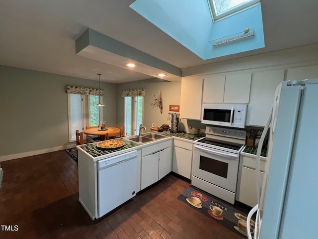 106 Orchard Rd, Henderson, NC 27536 - kitchen with white appliances, a sink, a skylight, a peninsula, and white cabinetry