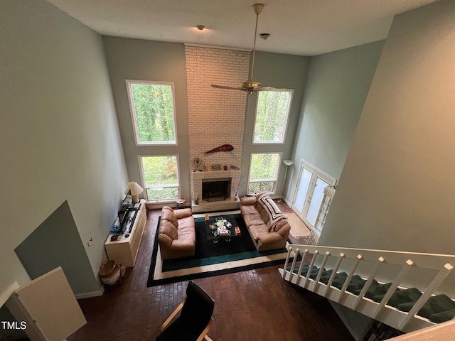 106 Orchard Rd, Henderson, NC 27536 - living room featuring a towering ceiling, wood finished floors, ceiling fan, and a brick fireplace