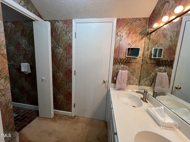 106 Orchard Rd, Henderson, NC 27536 - full bathroom featuring wallpapered walls, a textured ceiling, double vanity, and baseboards