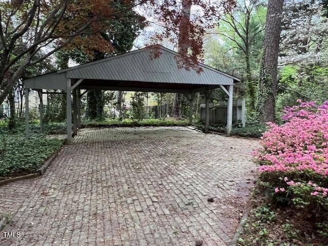 106 Orchard Rd, Henderson, NC 27536 - view of parking featuring a carport, decorative driveway, and fence