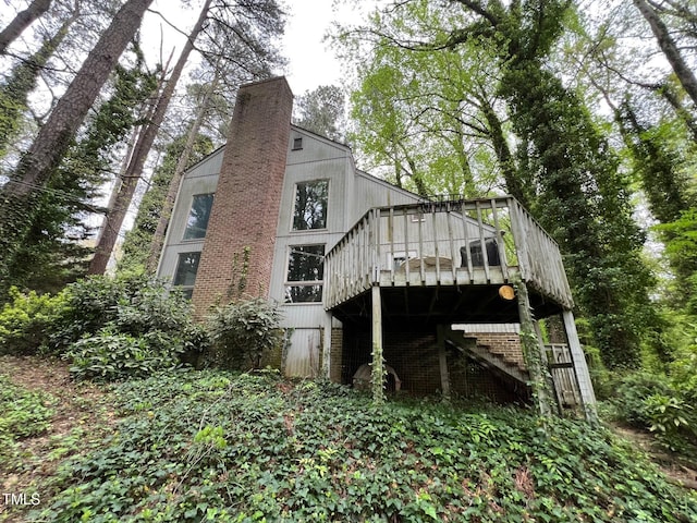 106 Orchard Rd, Henderson, NC 27536 - rear view of property featuring a wooden deck, brick siding, a chimney, and stairs