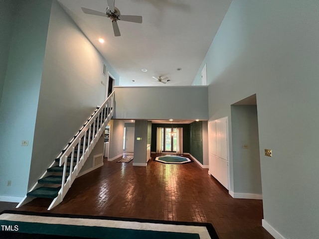 106 Orchard Rd, Henderson, NC 27536 - unfurnished living room with a ceiling fan, a high ceiling, stairway, baseboards, and wood-type flooring