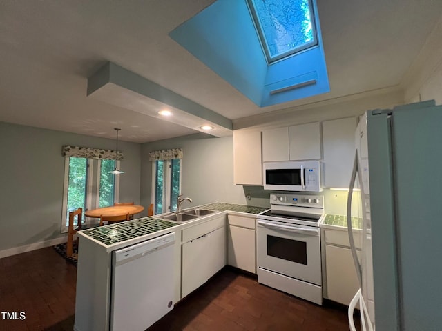 106 Orchard Rd, Henderson, NC 27536 - kitchen with white appliances, a peninsula, a skylight, white cabinetry, and recessed lighting