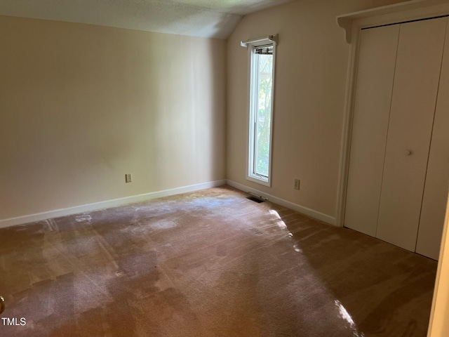 106 Orchard Rd, Henderson, NC 27536 - unfurnished bedroom with light colored carpet, baseboards, multiple windows, lofted ceiling, and a closet